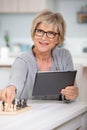 senior woman playing chess and holding tablet pc Royalty Free Stock Photo