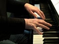 Senior woman playing piano. Close up side view of elderly hands and fingers playing a song Royalty Free Stock Photo