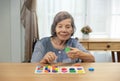 Senior woman playing wooden shape puzzles game for dementia prevention