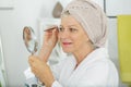 Senior woman plucking eyebrows Royalty Free Stock Photo