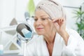 Senior woman plucking eyebrows with tweezers Royalty Free Stock Photo
