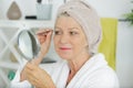 Senior woman plucking eyebrows with tweezers Royalty Free Stock Photo