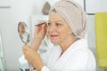 senior woman plucking eyebrows with tweezers Royalty Free Stock Photo