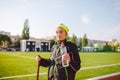 Senior woman practicing nordic walking at city stadium and stopped to quench thirst, drink water from bottle. Age, maturity, Royalty Free Stock Photo