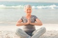 Senior woman practicing yoga on the beach