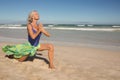 Senior woman practising yoga on sand Royalty Free Stock Photo