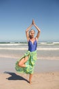 Senior woman practising yoga while standing against sea Royalty Free Stock Photo