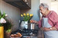Senior woman preparing traditional easter meals for family, boiling eggs. Recreating family traditions and customs.