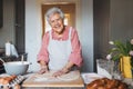 Senior woman preparing traditional easter meals for family, kneading dough for easter cross buns. Recreating family Royalty Free Stock Photo