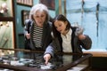 Senior woman and preteen girl observing antique pistols in museum