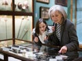 Senior woman and preteen girl observing antique pistols in museum