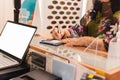 Senior woman in protective mask signing credit card in clothing store.