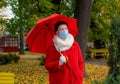 Senior woman protective medical mask autumn park age middle 50 plus umbrella red orange Royalty Free Stock Photo