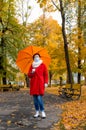 Senior woman protective medical mask autumn park age middle 50 plus umbrella red orange Royalty Free Stock Photo