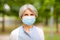 Senior woman in protective medical mask in park Royalty Free Stock Photo