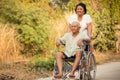 Senior woman pushing her disabled husband on wheelchair Royalty Free Stock Photo