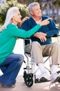 Senior Woman Pushing Husband In Wheelchair Royalty Free Stock Photo
