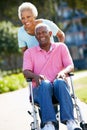 Senior Woman Pushing Husband In Wheelchair