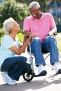 Senior Woman Pushing Husband In Wheelchair Royalty Free Stock Photo