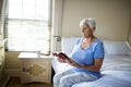 Senior woman reading a book in the bedroom Royalty Free Stock Photo