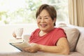 Senior Woman Reading Book With Drink At Home Royalty Free Stock Photo