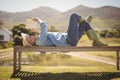 Senior woman reading a book while lying on the bench in the park Royalty Free Stock Photo