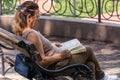 Tranquil Moments: Senior Woman Reading Book on Balcony Bench in Spa Resort