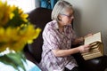 Senior woman reading book while sitting in nursing home Royalty Free Stock Photo