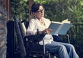 Senior woman reading a book in a wheelchair Royalty Free Stock Photo