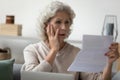 Senior woman reading letter feels disappointed having financial problems Royalty Free Stock Photo