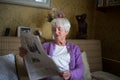 Senior woman reading morning newspaper