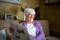 Senior woman reading morning newspaper