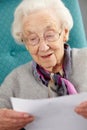 Senior Woman Relaxing In Chair Reading Letter Royalty Free Stock Photo