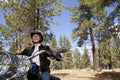 Senior woman riding motorcycle through a forest