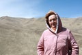 Senior woman on rocky ridge of Caucasus background