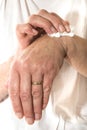 Senior woman rubbing her wrist with a pain relieving cream