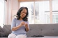 A senior woman's hand checking her blood sugar level with a glucometer by herself at her home. Royalty Free Stock Photo