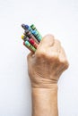 Senior woman`s hand holding multicolour crayon isolated on white background Royalty Free Stock Photo