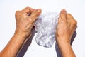 Senior woman hand squashing used plastic bottle, Water drops on transparent soft drink, White background, Global warming, Recycle Royalty Free Stock Photo