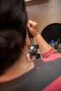 Senior woman`s hand touching squeezed fruit into a glass in the kitchen. She loves to prepare and consume a healthy diet