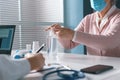 Senior woman sanitizing her hands at the doctor`s office