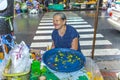 senior woman sells orange holy flowers to the local people at the night market Pak khlong Talat in Chinatown, Bangkok