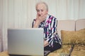 Senior woman shocked with something on laptop