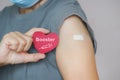 Senior woman show red heart shape with syringe icon, after vaccinated or inoculation booster dose due to spread of corona virus