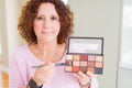 Senior woman showing nudes eyeshadows colors with a confident expression on smart face thinking serious