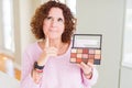 Senior woman showing nudes eyeshadows colors serious face thinking about question, very confused idea Royalty Free Stock Photo