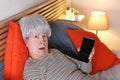 Senior woman showing smartphone screen in disbelief