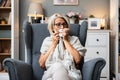 Senior woman sick and blowing nose at home from virus, allergy and illness on couch. Tired, tissue and elderly female person in a Royalty Free Stock Photo