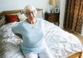 Senior woman sitting on the bed with back pain Royalty Free Stock Photo