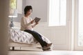 Senior Woman Sitting On Bed Looking At Photo Frame